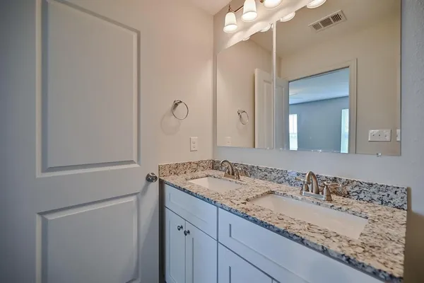 a bathroom with a granite countertop sink and a mirror