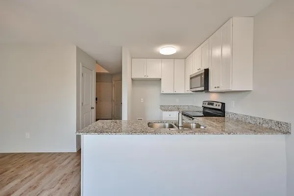 a kitchen with stainless steel appliances granite countertop a sink refrigerator and microwave