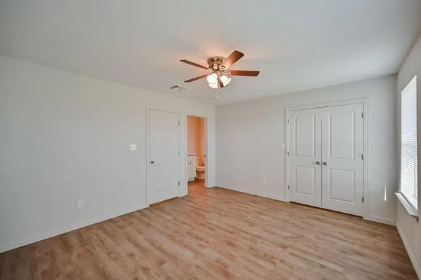 a view of a room with wooden floor and a ceiling fan