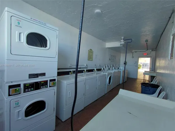 a room with kitchen island a sink dishwasher a dining table and chairs with wooden floor