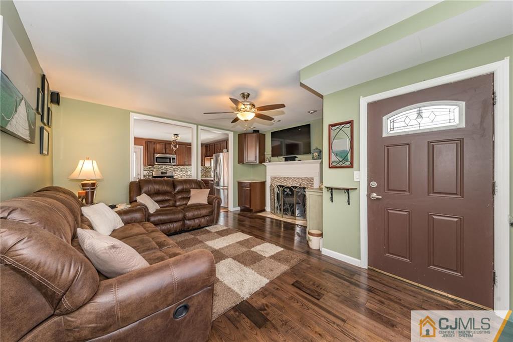 114 Dock Road Brick, NJ 08723 - Photo 4 of 25 a living room with furniture a dining table and a fireplace
