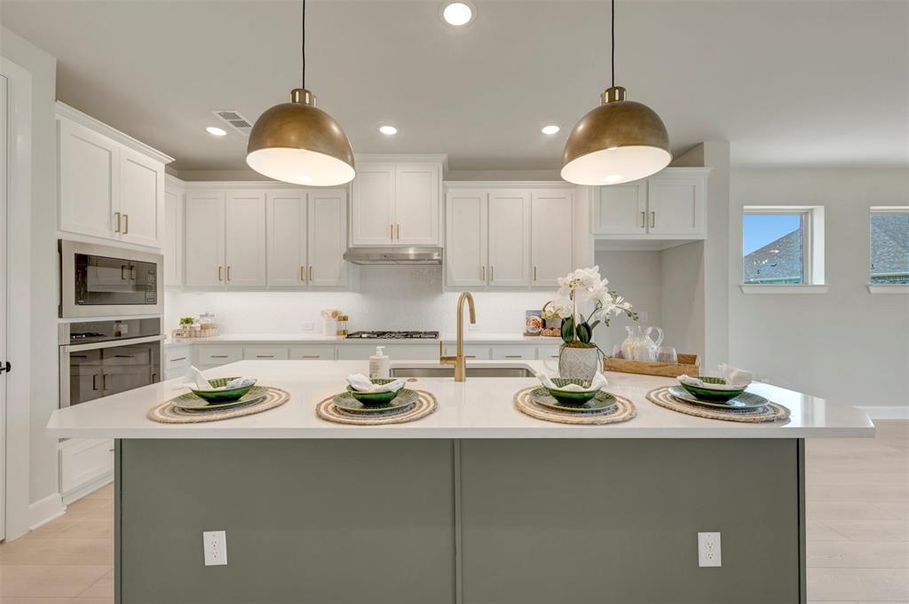 4308 Palomino Road Aubrey, TX 76227 - Photo 13 of 40 a kitchen with a stove a sink and cabinets