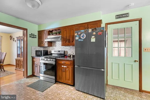 a kitchen with granite countertop a sink cabinets and stainless steel appliances