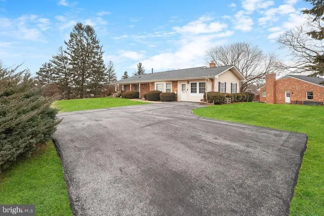 a view of a house with a yard and pathway