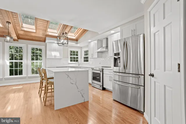 a kitchen with stainless steel appliances a refrigerator and wooden floor