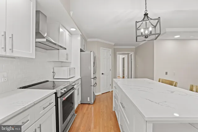 a kitchen with stainless steel appliances a stove a sink and a refrigerator