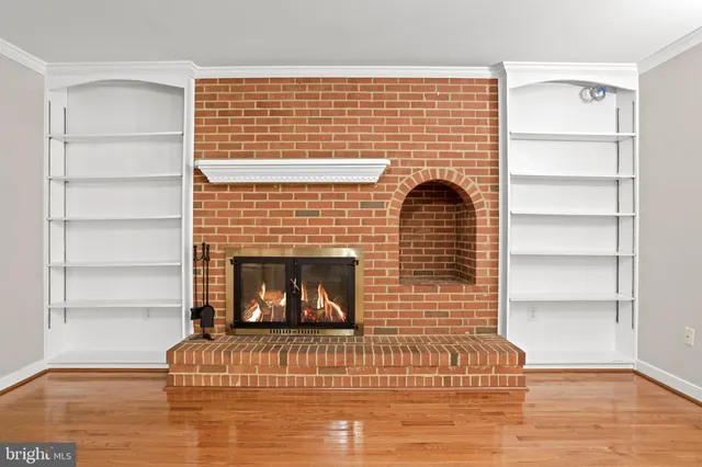 a living room with a fireplace and wooden floor