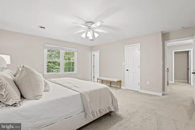 a spacious bedroom with a bed and a chandelier