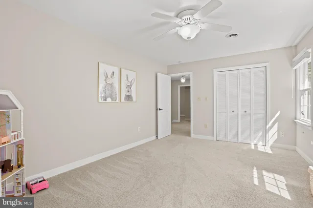 a view of an empty room with chandelier fan