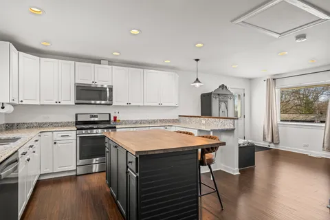 a bathroom with a granite countertop sink vanity mirror and toilet
