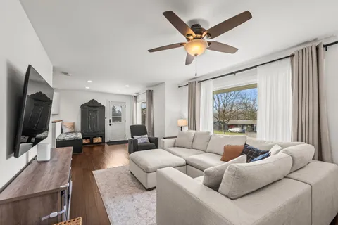 a view of a house with a big yard and large trees