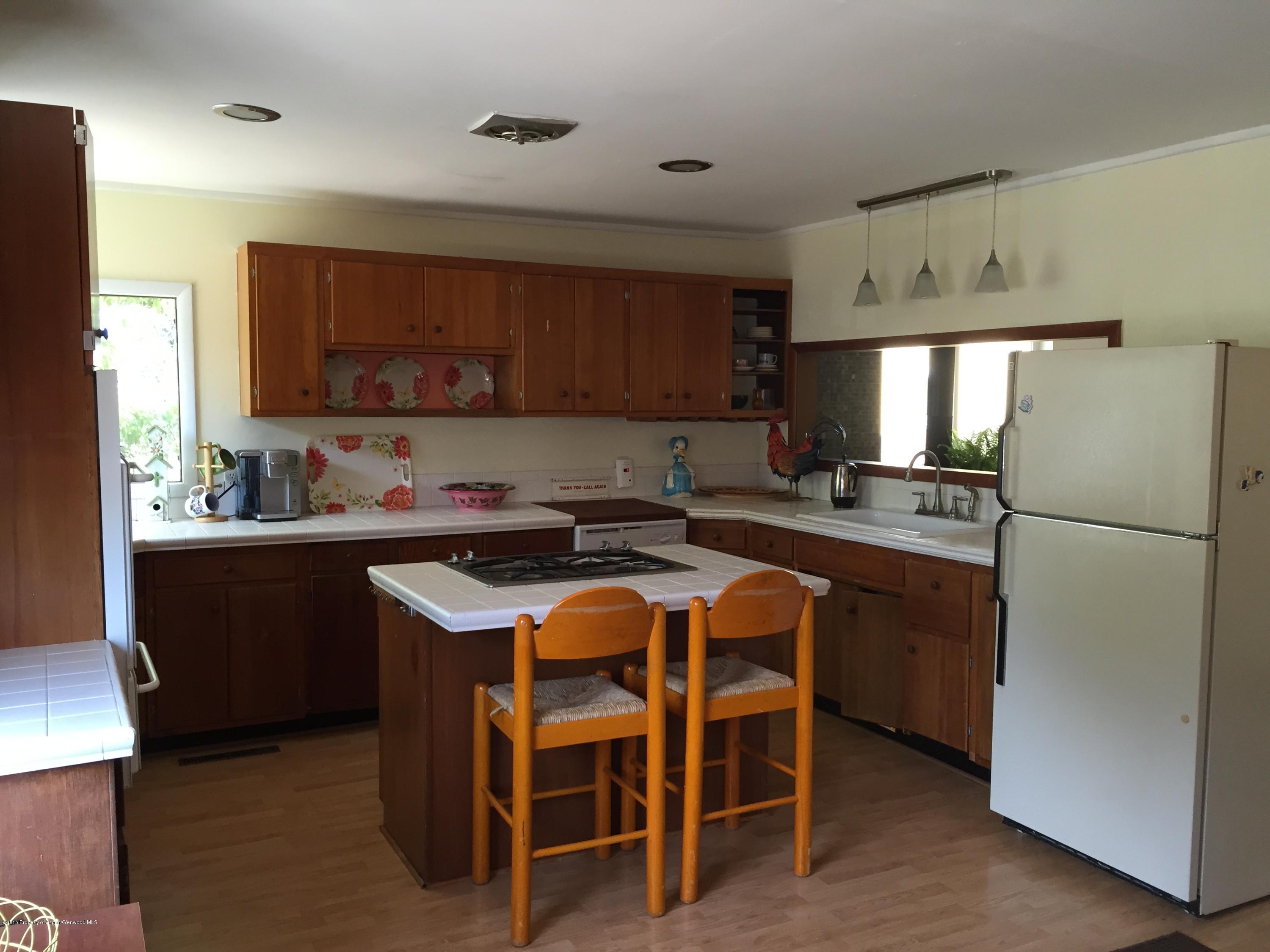 153 East 11th Street Rifle, CO 81650 - Photo 4 of 10 a kitchen with stainless steel appliances granite countertop a refrigerator a sink dishwasher a stove with wooden cabinets and floor