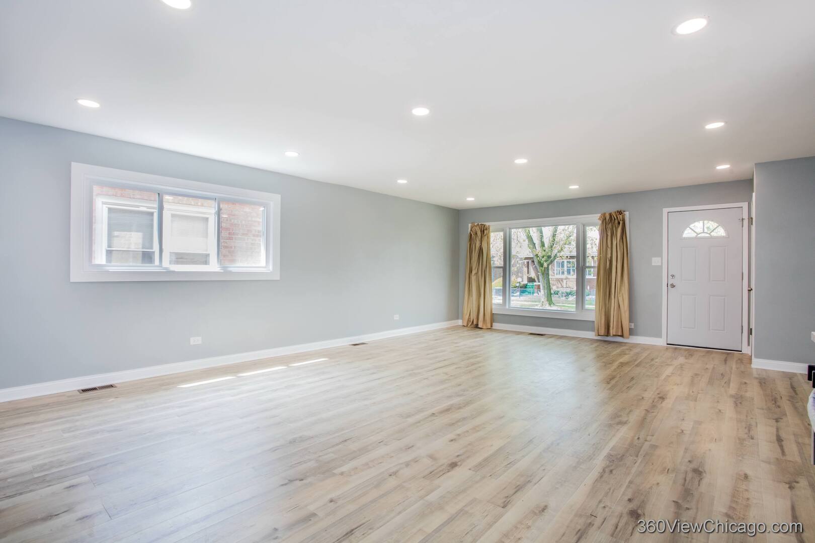 9015 South Carpenter Street Chicago, IL 60620 - Photo 3 of 23 a view of an empty room with wooden floor and windows