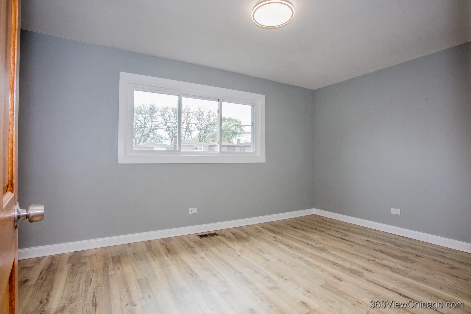 9015 South Carpenter Street Chicago, IL 60620 - Photo 9 of 23 wooden floor in an empty room with a window