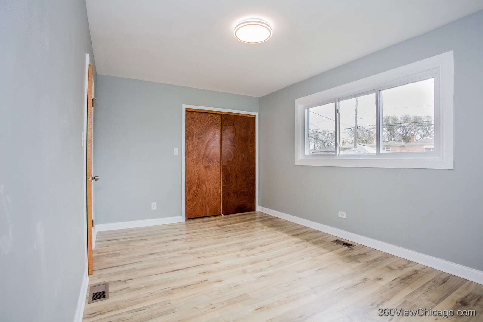 9015 South Carpenter Street Chicago, IL 60620 - Photo 10 of 23 a view of an empty room with wooden floor and a window