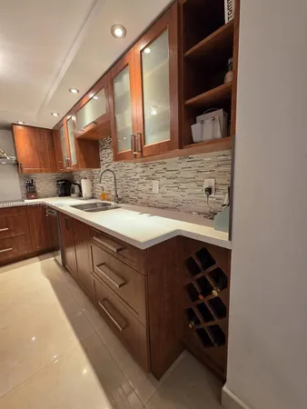 a view of a hallway with wooden floor and a bathroom