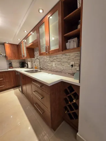 a view of a hallway with wooden floor and a bathroom