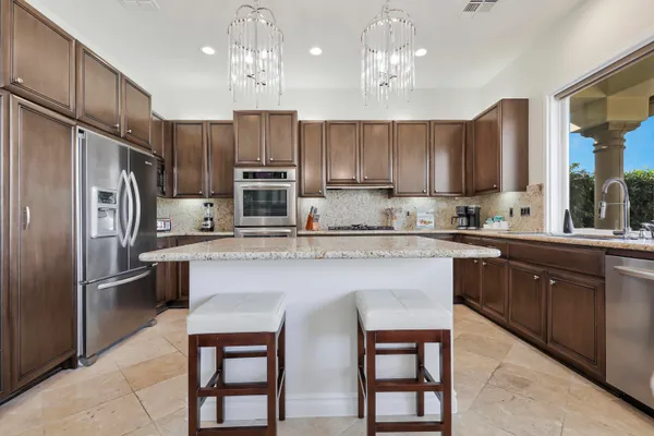 a kitchen with stainless steel appliances granite countertop a refrigerator sink and cabinets