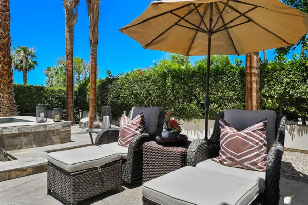 a view of an outdoor sitting area with furniture and umbrella
