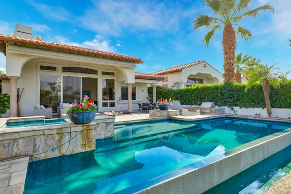 a view of a house with swimming pool and sitting area