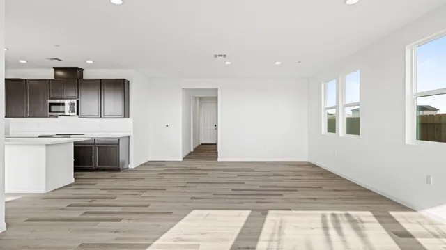 a large white kitchen with granite countertop a stove and a sink