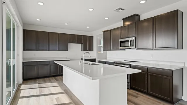 a kitchen with stainless steel appliances a sink stove and refrigerator