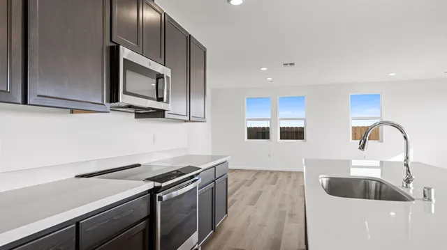 a kitchen with a sink and a stove top oven