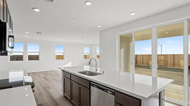a view of a kitchen counter top a sink and living room view