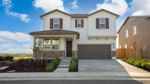 a front view of a house with garage and parking