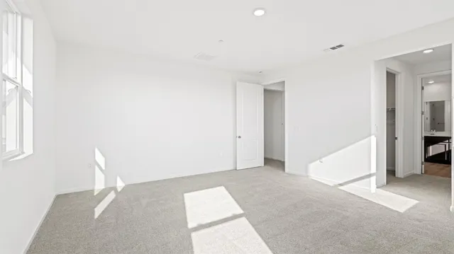 a walk in closet with view of bathroom