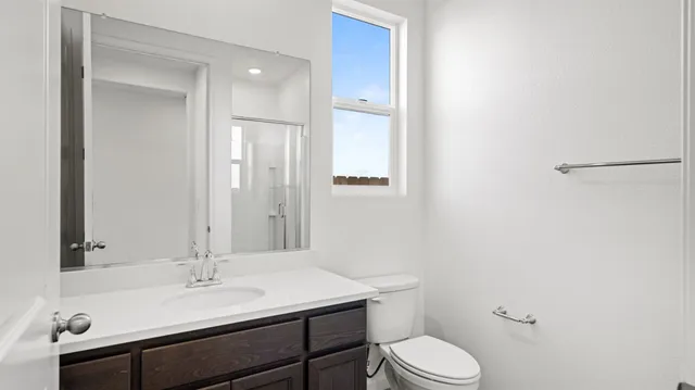 a bathroom with a sink toilet vanity and shower