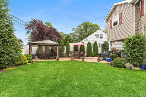 a view of a house with backyard sitting area and garden