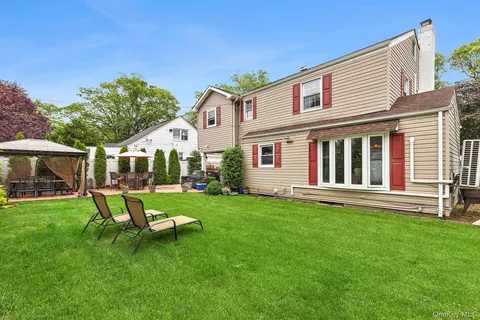 a view of a house with backyard sitting area and garden