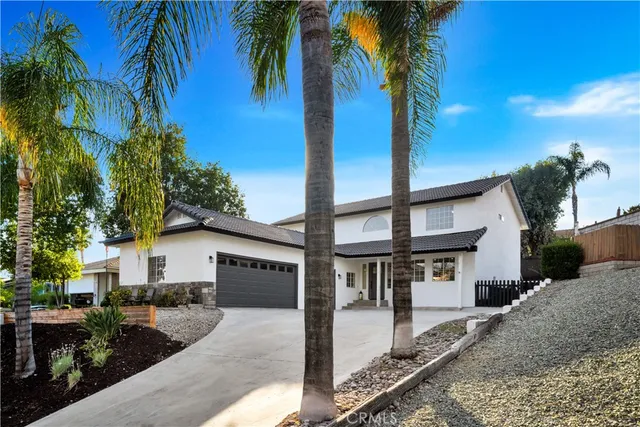 a front view of a house with yard and tree