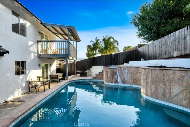 a view of a patio with table and chairs and wooden fence