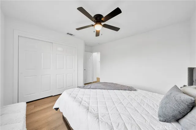 a view of empty room with wooden floor and fan