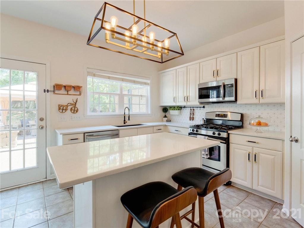 2405 Coltsgate Road Waxhaw, NC 28173 - Photo 26 of 48 a kitchen with granite countertop a stove a sink and a microwave