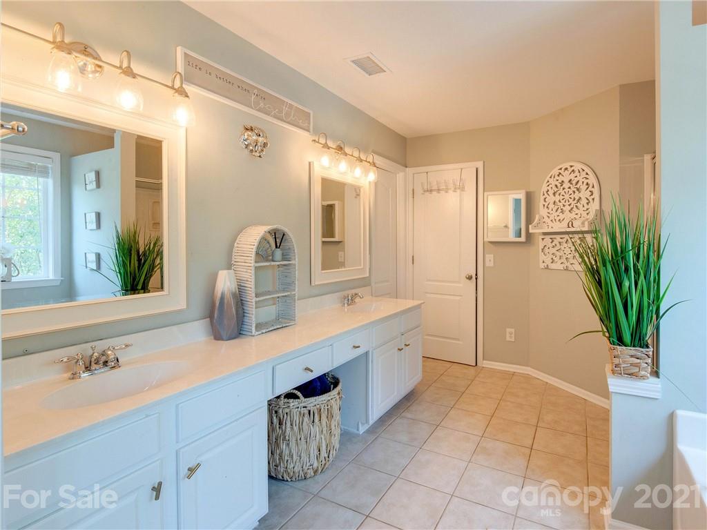 2405 Coltsgate Road Waxhaw, NC 28173 - Photo 33 of 48 a bathroom with a sink a large mirror and a bathtub