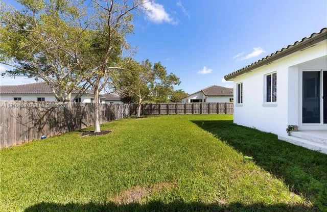 a view of a house with backyard and sitting area