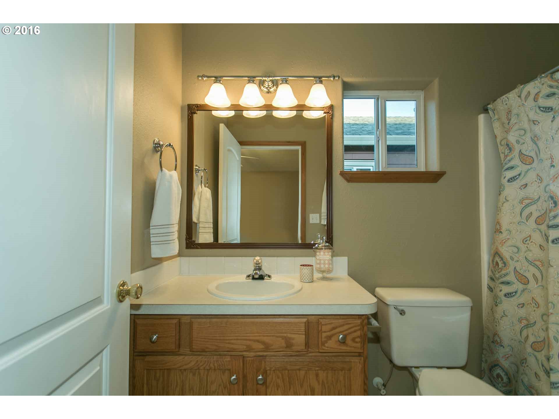1908 Southeast 122nd Avenue Portland, OR 97233 - Photo 8 of 11 a bathroom with a sink mirror and toilet