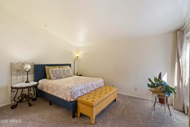 a bedroom with a bed table and a chair