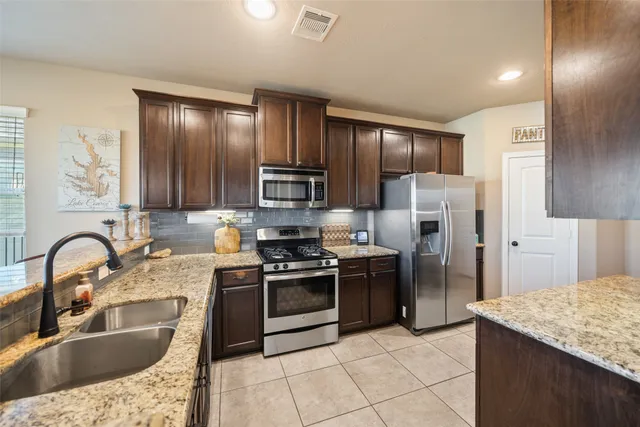 a bedroom with a large bed a flat tv screen and a dresser