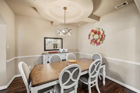 a view of a dining room with furniture a chandelier and wooden floor
