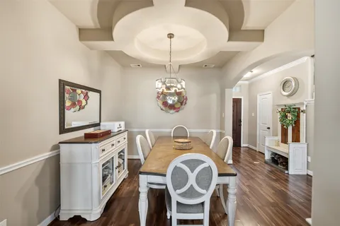 a view of a dining room with furniture wooden floor and a chandelier