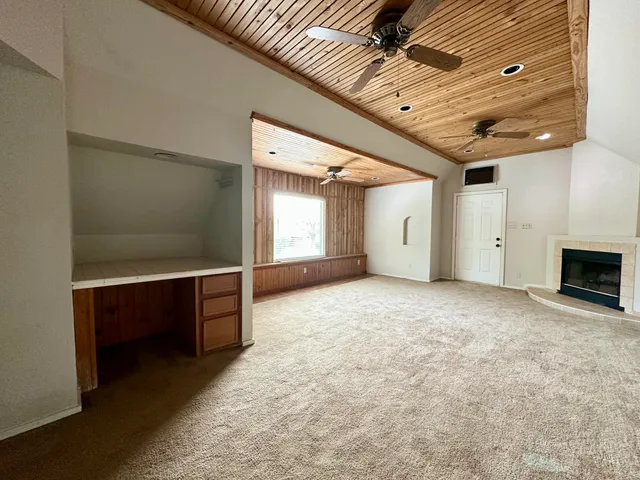 a view of an empty room with a fireplace and a window