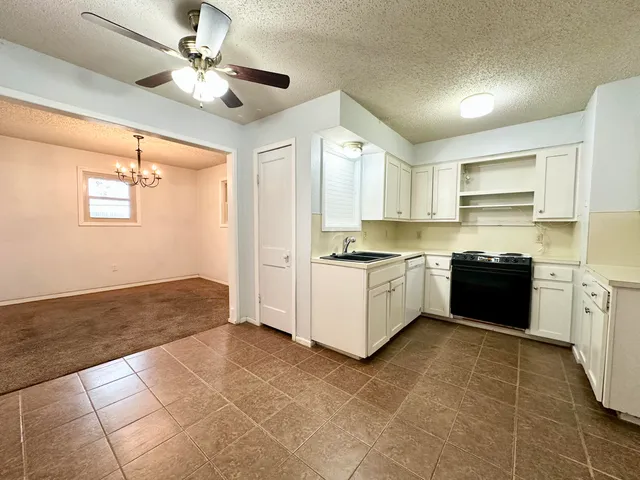 a large kitchen with a stove a sink dishwasher and a refrigerator