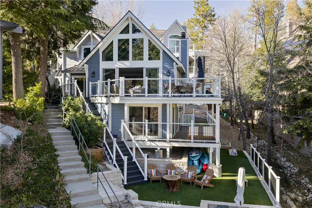 27589 West Shore Road Lake Arrowhead, CA 92352 - Photo 5 of 11 a view of a white house with large windows and a table and chairs