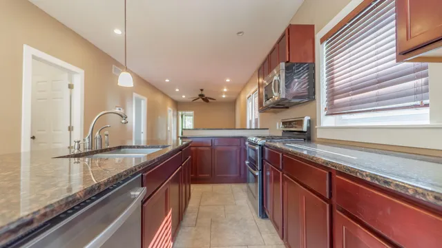 a kitchen with granite countertop a sink and cabinets