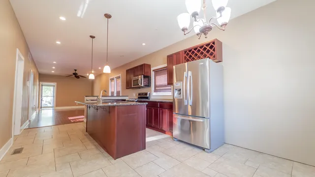 a kitchen with stainless steel appliances granite countertop a refrigerator a oven and a sink