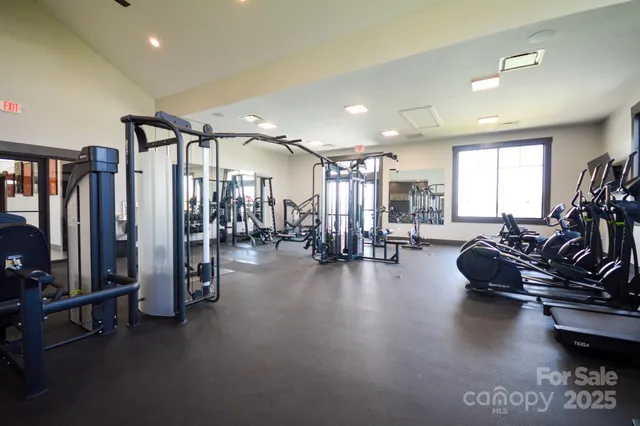a gym room with gym equipment and a large window